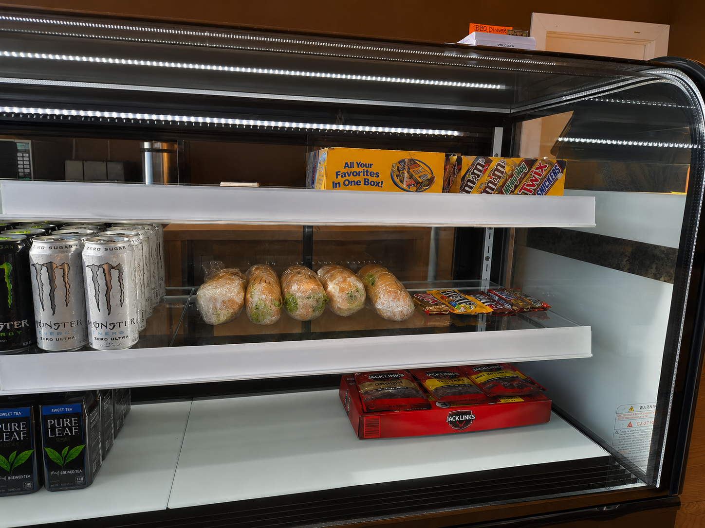 Grab and go cooler at Big Tony's stocked with wrapped sandwiches, cold drinks, jerky, and candy